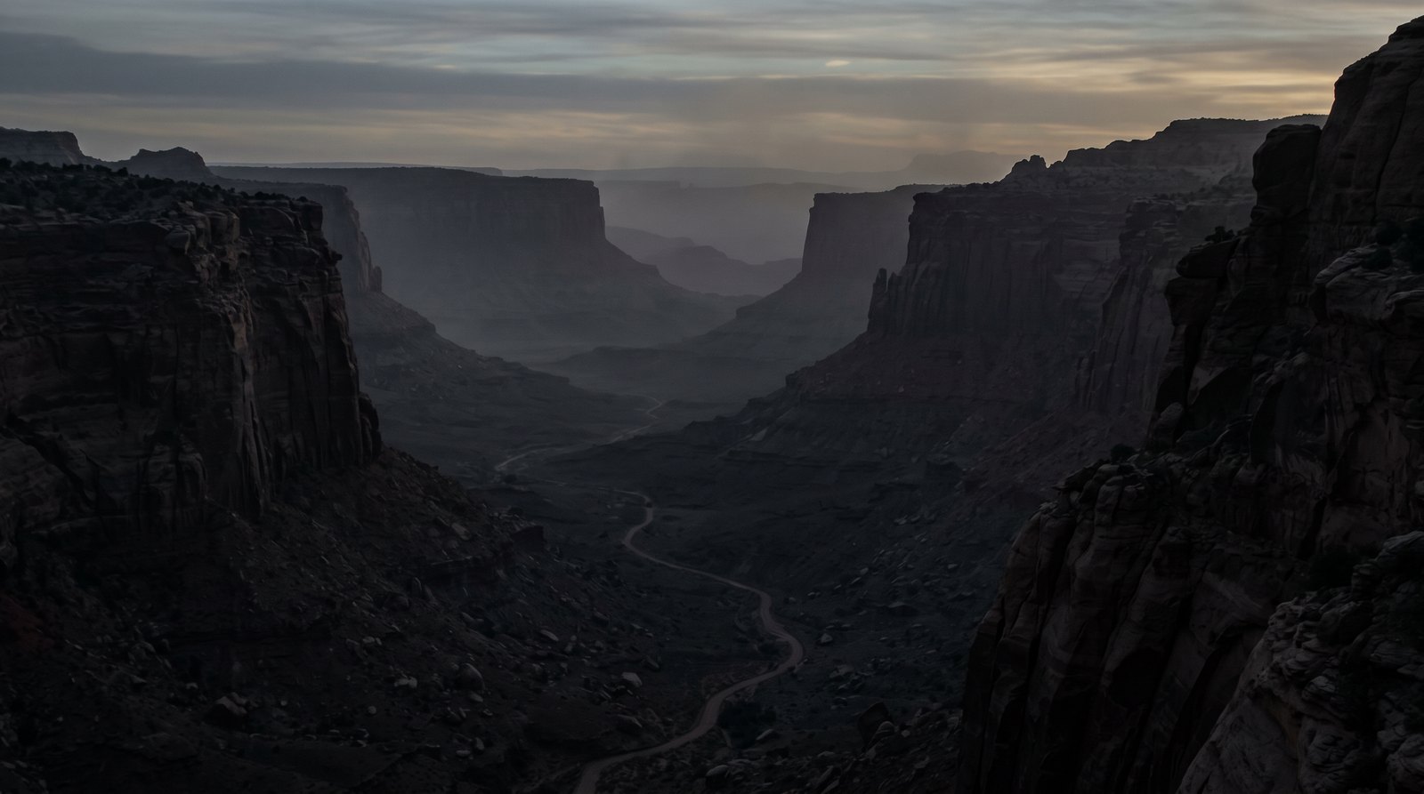 Long-lens view of a deep canyon approach corridor at failing light